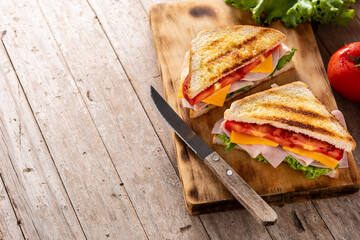 Sandwich with tomato,lettuce,ham and cheese on wooden table