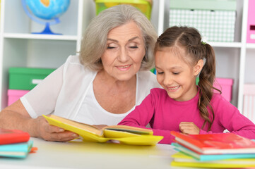 Canvas Print - Little girl doing homework with her grandmother at home