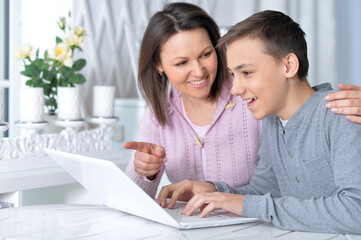 Wall Mural - Emotional mother and son using modern laptop