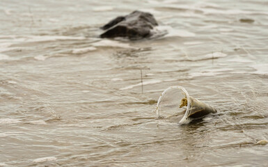 Plastic pollution \ Disposable plastic cups on the beach