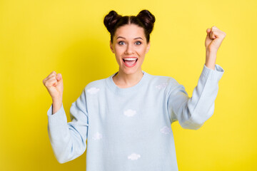 Wall Mural - Photo of cheerful astonished lady raise fists open mouth wear blue pullover isolated yellow background