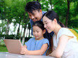 © eastfenceimage - Happy family of three uses tablet computer outdoors