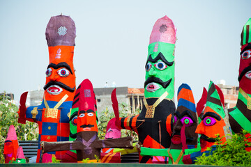 roadside streetside shot of huge paper mache effigies puppets of demon ravana being built in colorful paper to be burnt on the eve of dussehra Vijayadashami to be filled with fireworks for the hindu f