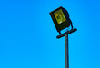 Outdoor waterproof floodlight on a pole on blue sky background