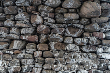 Wall Mural - Texture of a stone wall. Old castle stone wall texture background. Stone wall as a background or texture. Part of a stone wall, for background or texture. High quality photo