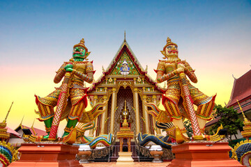 Two Giants statues holding their batons in front of thai temple entrance. Giant green and the giant white at Wat Sa Mani Buddha temple Ban Phak Top, Nong Han District, Udon Thani Province, Thailand. 