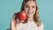 © Anton - Cheerful teenager girl with wavy hair offering red apple on came
