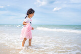 Fototapeta Tęcza - Funny asian girl playing on summer tropical beach in Thailand