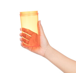 Sticker - hand holding Empty plastic orange cup isolated on white background