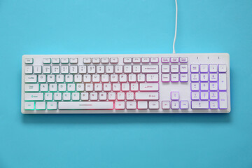 Wall Mural - Modern RGB keyboard on turquoise background, top view