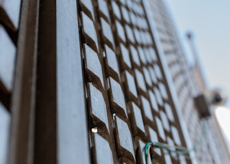 A grate on the side of a building with the background blurred on a blue sky