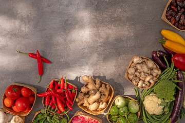 Wall Mural - Fresh vegetables from organic farm in eco-friendly containers made from natural materials on gray background. Copy space