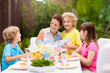 © famveldman - Family eating outdoor. Garden summer fun.