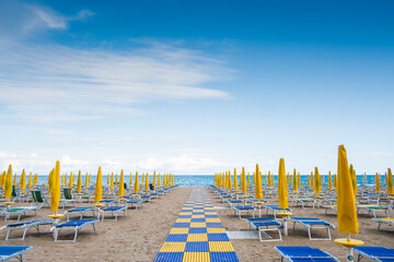 Wall Mural - Beach resort with sun beds and beach umbrellas