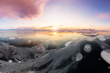 Sticker - landscape pink clouds at dawn on cape khoboy olkhon island lake Baikal in winter on ice with cracked and large white bubbles