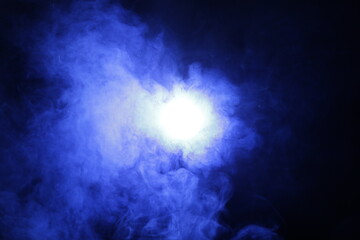 Poster - Artificial magic smoke in blue light on black background