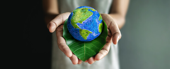 World Earth Day Concept. Green Energy, Renewable and Sustainable Resources. Environmental and Ecology Care. Hand Embracing Green Leaf and Handmade Globe