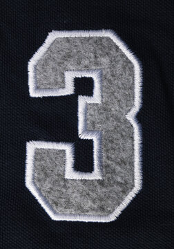 Numbers seven 7 and three 3 in fabric on a blue T-shirt. 