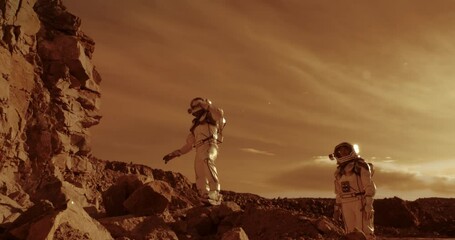 Wall Mural - Astronauts climbing rocks and looking away on Mars