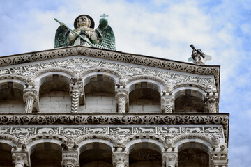 Poster - Lucca (Tuscany, Italy), church of San Michele. Details of the columns and arches of the medieval facade, with inlays and sculpture of sirens, monsters, dragons and animals