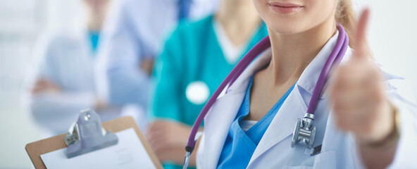 Young happy female doctor showing thumbs up