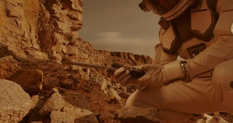 unrecognizable astronaut analyzing soil of mars