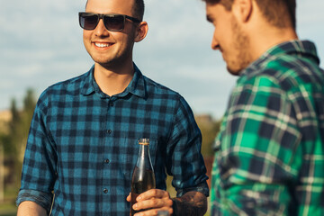 Wall Mural - Two young men with beer drinks, doing barbecue in nature, fashionable people preparing meat, youth lifestyle