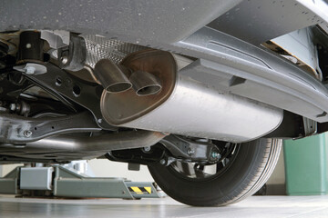 A muffler installed on a modern car. Bottom view of the car.