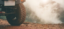 Part Of An Off-road Vehicle On A Dirt Road With Warm Light. Adventure Concept.Tire Off-road On Mud