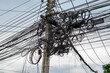 © kuarmungadd - Wires and cables are installed disorderly on electric poles, it can be dangerous: Infrastructure Safety Concepts.
