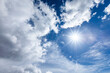 © Tetra Images - Sun flare in blue sky with clouds