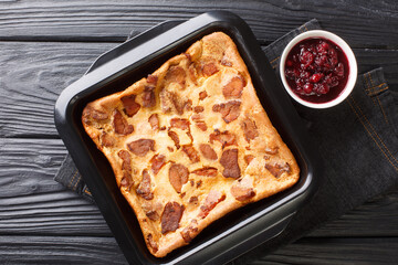 Swedish pancake Flaskpannkaka with meat close-up in a baking dish on the table. Horizontal top view from above