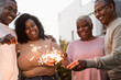 © Alessandro Biascioli - Happy African family celebrating with sparklers fireworks at house party - Parents unity and holidays concept