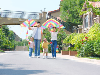 Happy family of four flying kites outdoors