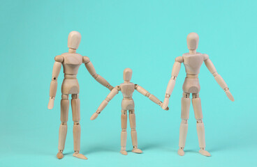 Wall Mural - Happy family concept. Wooden puppets of mother father and child on blue background