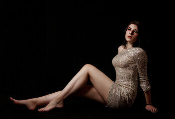 young beautiful girl posing sitting on floor in the studio