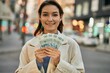 © Krakenimages.com - Young hispanic woman smiling happy holding polish zloty banknotes at the city