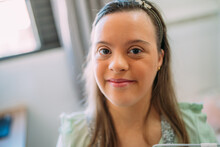 Close Up Portrait Of Friendly Young Latin Woman With Down Syndrome.