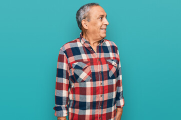 Sticker - Senior hispanic man wearing casual clothes looking away to side with smile on face, natural expression. laughing confident.