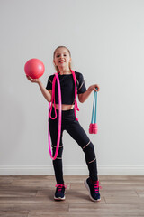 Young professional gymnast girl posing with equipment