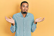 © Krakenimages.com - Young african american man wearing casual clothes clueless and confused expression with arms and hands raised. doubt concept.