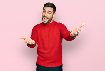 Young hispanic man wearing casual clothes smiling cheerful offering hands giving assistance and acceptance.