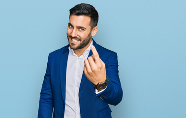 Canvas Print - Young hispanic man wearing business jacket beckoning come here gesture with hand inviting welcoming happy and smiling