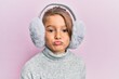 Little beautiful girl wearing fluffy earmuff looking at the camera blowing a kiss being lovely and sexy. love expression.