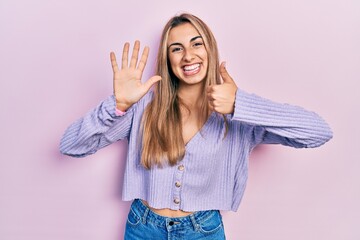 Sticker - Beautiful hispanic woman wearing casual shirt showing and pointing up with fingers number six while smiling confident and happy.