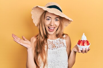 Canvas Print - Young caucasian woman wearing summer style holding ice cream celebrating achievement with happy smile and winner expression with raised hand