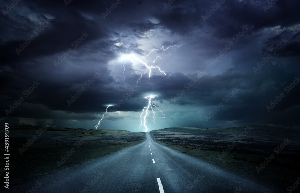 Extreme weather conditions. An empty landscape with a road leading into ...