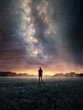 © James Thew - A man Exploring the night sky as the Milky Way galaxy fills the landscape from above. Photo composite