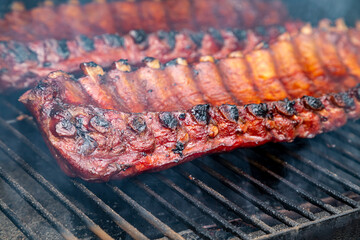 2 slabs of ribs smoking on grill outside