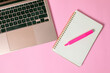 © JP STUDIO - computadora junto con una libreta y un marcatextos, en fondo uniforme con todo rosa pastel